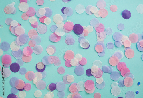 Multicolored confetti and sparkles on blue background.