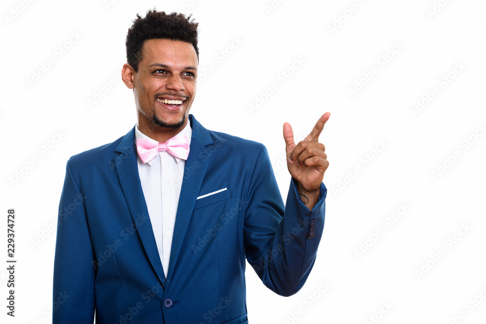 Studio shot of young happy African businessman smiling while thi Studio shot of young happy African businessman smiling while thi