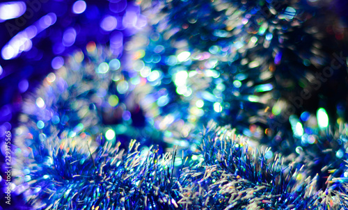 Decorated Christmas tree on blurred, sparkling and fairy elegant abstract background with bokeh lights and stars. Glowing abstract black and purple abstract texture. Circular points. Raster image.