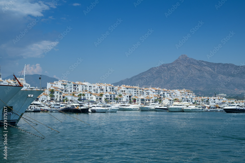 Puerto Banus, Marbella, Costa del Sol, Spain. Whitewashed buildings and shops serve as a backdrop to nthis harbour of marine vessels of all sizes from small dinghies to luxury yachts. Puerto Banus, Marbella, Costa del Sol, Spain. Whitewashed buildings and shops serve as a backdrop to nthis harbour of marine vessels of all sizes from small dinghies to luxury yachts.