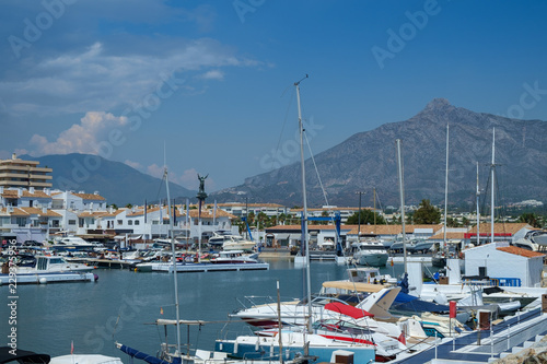 Puerto Banus, Marbella, Costa del Sol, Spain. Whitewashed buildings and shops serve as a backdrop to nthis harbour of marine vessels of all sizes from small dinghies to luxury yachts. photo