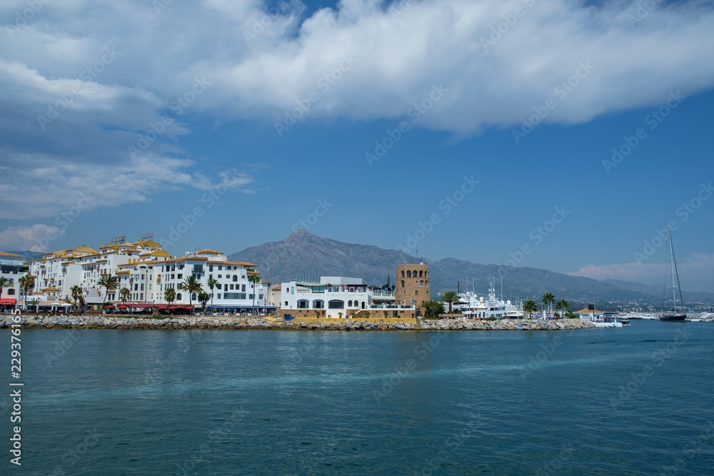 Puerto Banus, Marbella, Costa del Sol, Spain. Whitewashed buildings and shops serve as a backdrop to nthis harbour of marine vessels of all sizes from small dinghies to luxury yachts.