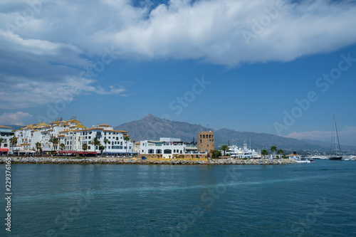 Puerto Banus, Marbella, Costa del Sol, Spain. Whitewashed buildings and shops serve as a backdrop to nthis harbour of marine vessels of all sizes from small dinghies to luxury yachts. photo