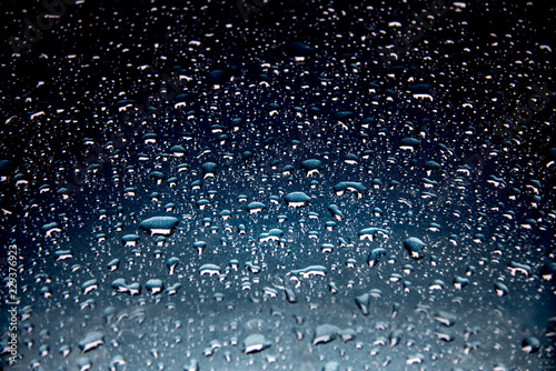 Rain drops on the blue background light on the water drops.