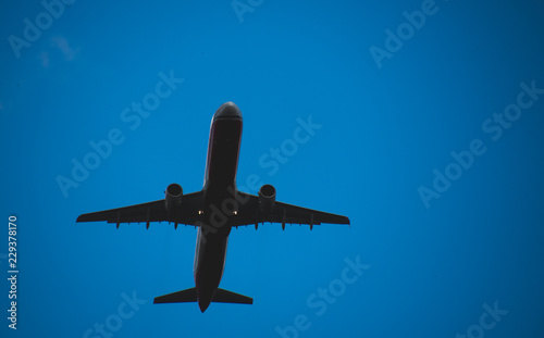 Silhouette of a plane taking off against the blue sky