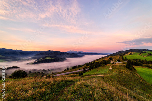 Beautiful sunrise over high rocky peaks and misty and foggy valley in High Tatras mountains on Slovak and Polish border.