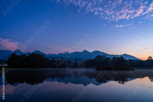 Blue hour shot of peaceful scene of beautiful autumn mountain landscape with lake  colorful trees and high peaks in High Tatras  Slovakia.