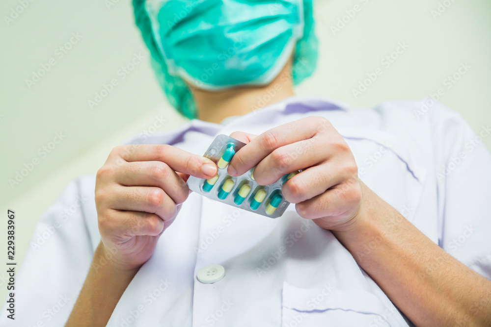 The doctor is tearing a capsule pack The doctor is tearing a capsule pack