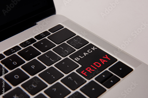 close-up shot of laptop keyboard with black friday button isolated on white photo