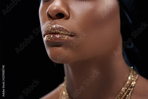 cropped shot of african american woman with sparkling lip gloss isolated on black