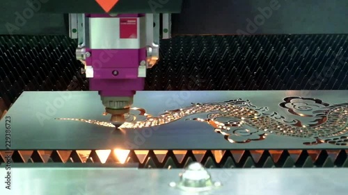 Close-up and inside of laser cutting machine, which is working in the cutting of steel plate according to the pattern set by the machine program, on industrial factory, industry 4.0