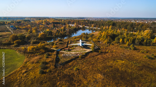 Aerial view of the plane in the autumn forest near the lake and beatiful landscape. Beautiful autumn landscape with a plane.