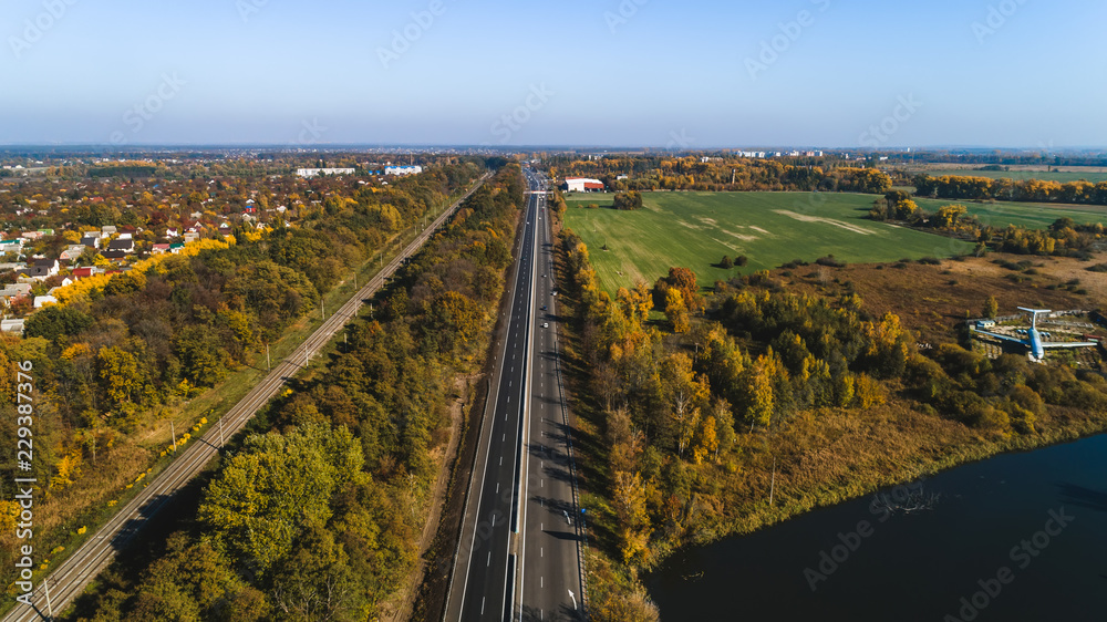 Aerial view of the rural traffic near lake and airplane.