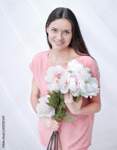 portrait of a young woman with a bouquet of peonies