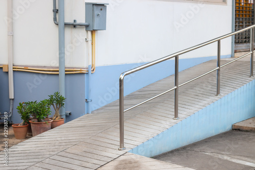 Ramp way with stainless steel handrail for support wheelchair disabled people infront of the building