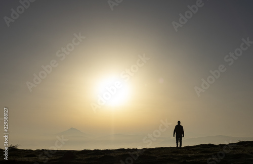 Man on the top of the hill watching wonderful scenery of colorful sunrise in mountains of Basque Country