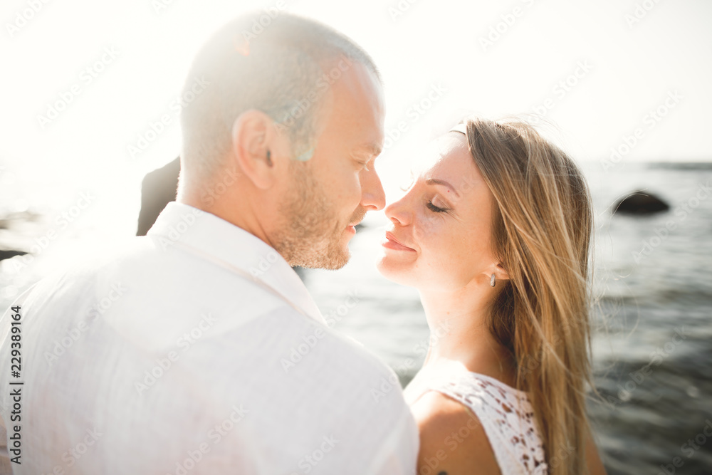 happy just married young wedding couple celebrating and have fun at beautiful beach sunset