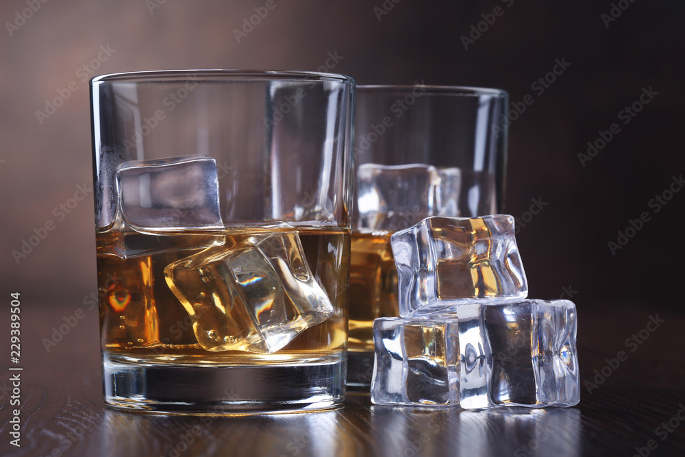 Glasses with whiskey and ice cubes Glasses with whiskey and ice cubes