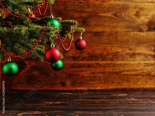 Christmas tree, dressed up balls, stands on a wooden table. Copy space.