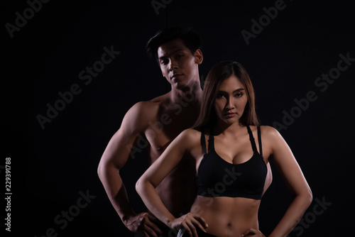 The man and woman with muscular torso on black background,show fit and firm body,strong muscle