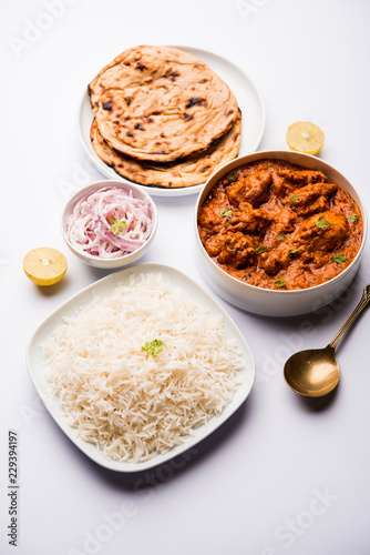 Murgh Makhani / Butter chicken tikka masala served with roti / Paratha and plain rice along with onion salad. selective focus
