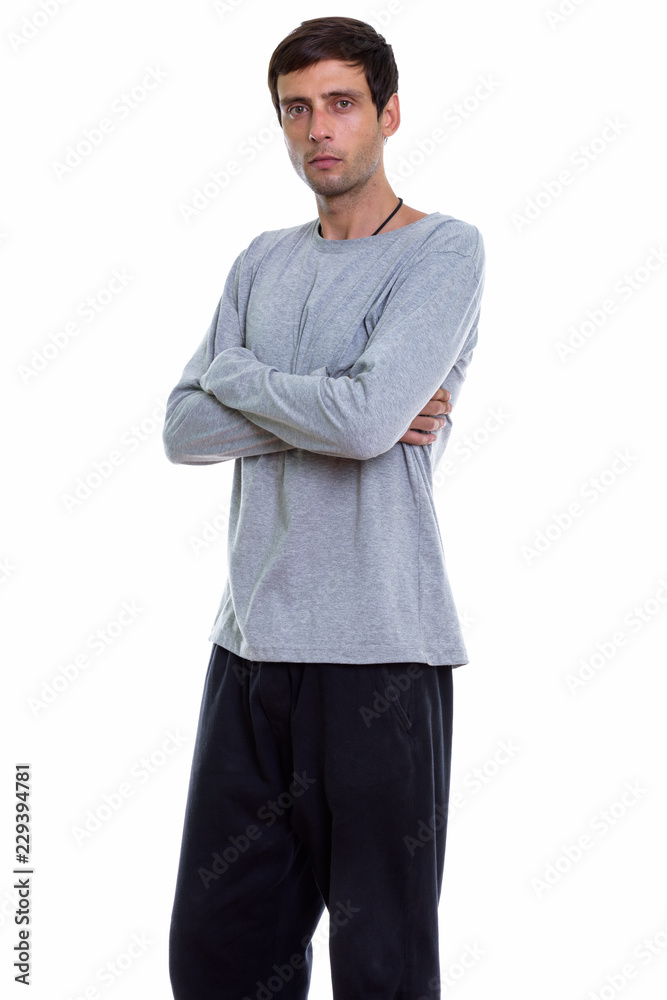 Studio shot of young handsome man standing with arms crossed Studio shot of young handsome man standing with arms crossed