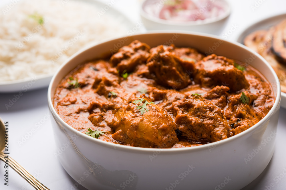 Murgh Makhani / Butter chicken tikka masala served with roti / Paratha and plain rice along with onion salad. selective focus Murgh Makhani / Butter chicken tikka masala served with roti / Paratha and plain rice along with onion salad. selective focus