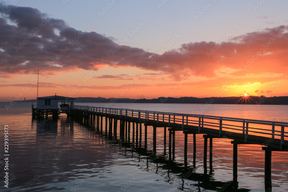malerischer Sonnenuntergang und dramatische Wolken an einer schönen Seebrücke
