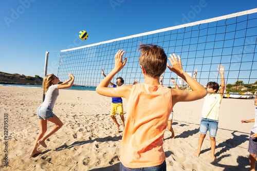 Sporty young girl passing volleyball over the net