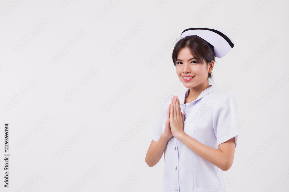 friendly smiling female nurse with Asian Thai style welcoming gesture friendly smiling female nurse with Asian Thai style welcoming gesture