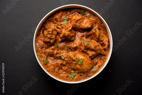 Murgh Makhani / Butter chicken tikka masala served with roti / Paratha and plain rice along with onion salad. selective focus