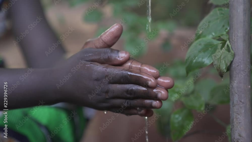 Little black girl washing and cleaning her hands outdoors. 4K RAW clip, please modify and edit (color grade, stabilize, etc.) in postproduction. Little black girl washing and cleaning her hands outdoors. 4K RAW clip, please modify and edit (color grade, stabilize, etc.) in postproduction.
