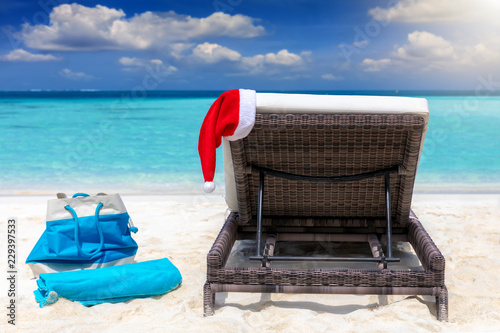 Weihnachts Urlaub Konzept  Sonnenliege am tropischen Strand mit Weihnachts M  tze