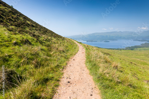 a path up a hill and Loch Lomond