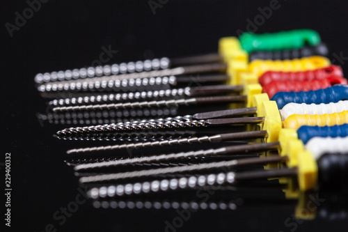 dental and endodontic restoration instruments on a black dark background. Top view photo