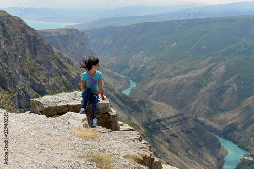 Sulak canyon in Dagestan, one of the deepest in the world. The woman enjoys the view of the canyon and the turquoise river Sulak.