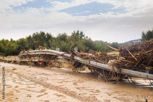 Damaged infraestructure after natural disaster: Detail of guardrails in closed road by muddy flood and overflow of a river during historic storm in Seville and Malaga, Spain.