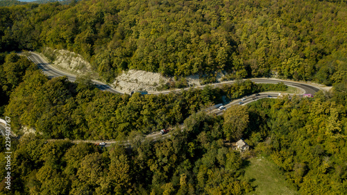 Directly above view of cars on a curvy road. Aerial drone shoot in the mountains.