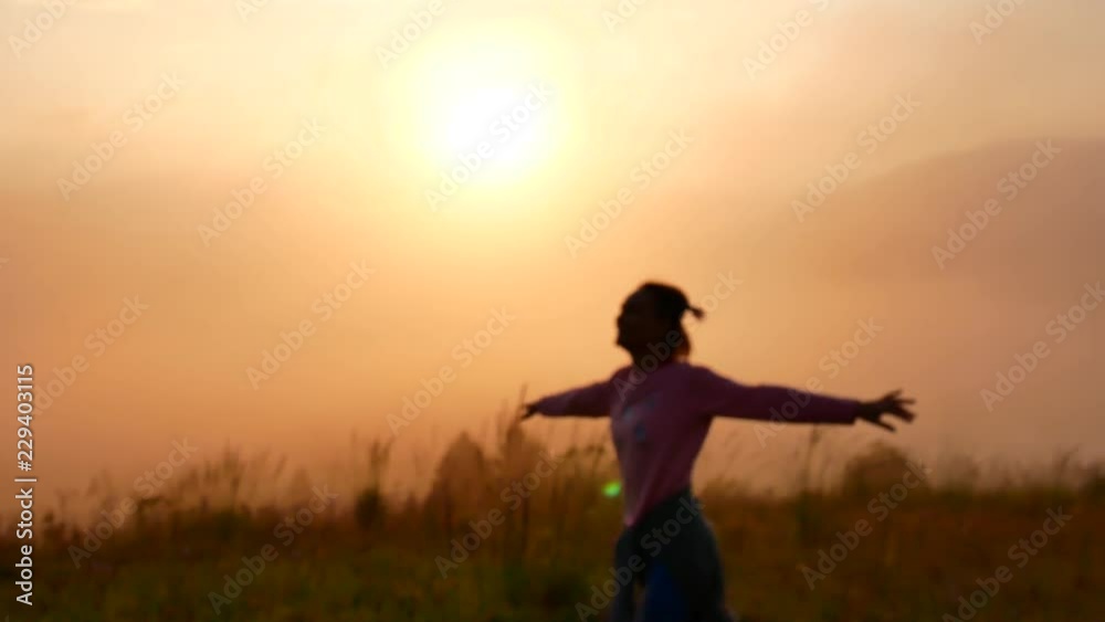 A young woman is spinning at sunrise in the mountains. A young woman is spinning at sunrise in the mountains.