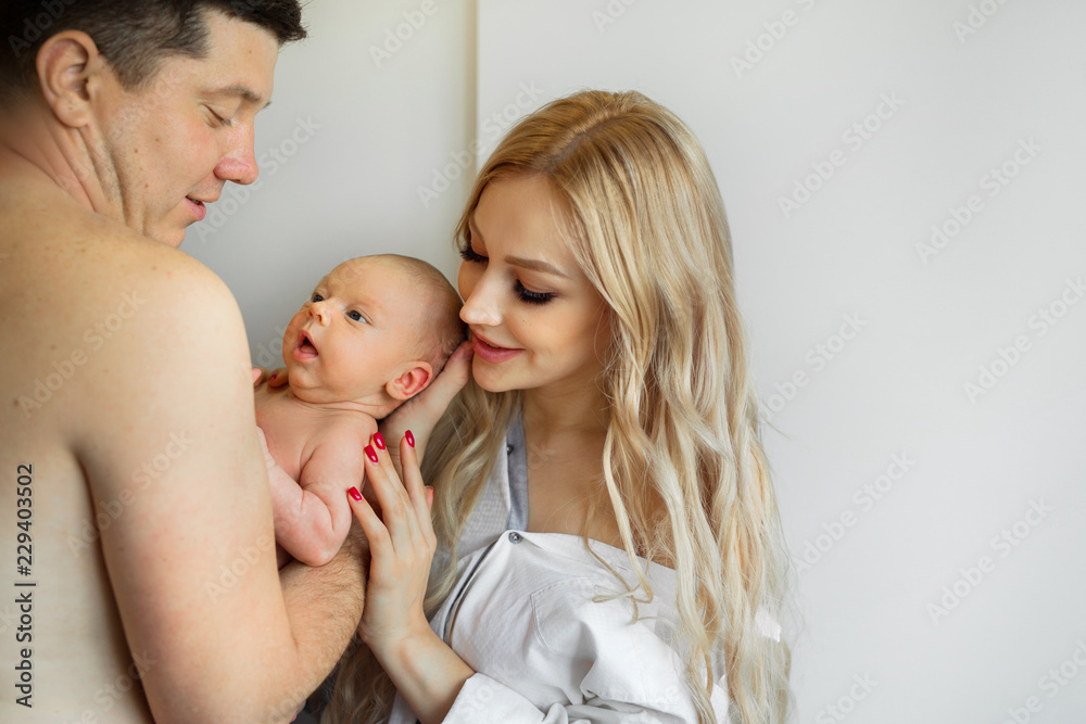 beautiful young family holding their baby in their arms at home	