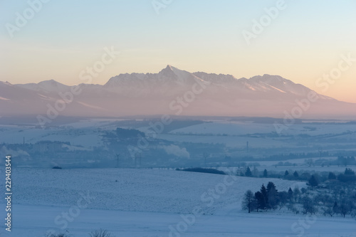 Scenic view of snow-covered fields and sunrise in the High Tatras mountains.