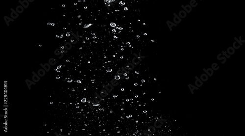 Blurred images of close-up soda water bubbles fizzing up or splashing or sparkling like a exploding of a bomb on black background for represent refreshing from carbonated drinks menu.
