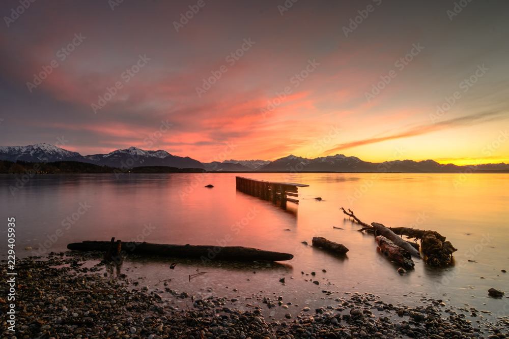 Fototapeta premium Sonnenuntergang hinter den Bergen im Winter am See