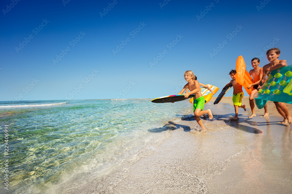 Boy running into sea leaping onto his body board Boy running into sea leaping onto his body board
