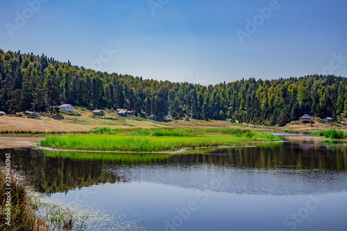 Houses and trees surrounding the lake in the middle of the plateau,