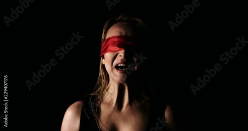 Young woman with red ribbon on her eyes