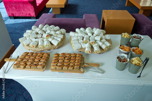 Business and entrepreneurship. The waitress filed a glass of white coffee with the sausage between the brake and the brake food background. Paxlava , Pakhlava . Coffee break at conference meeting. photo