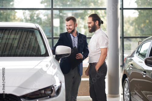 Manager showing to customer of car center white automobile.