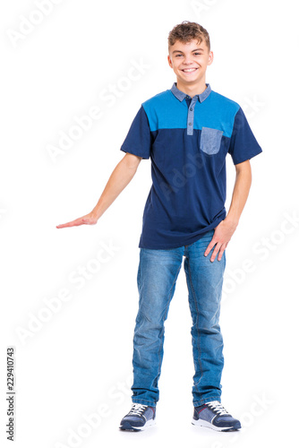 Full length portrait of young caucasian teen boy isolated on white background. Funny teenager showing something by hand. Handsome child looking at camera and smiling.