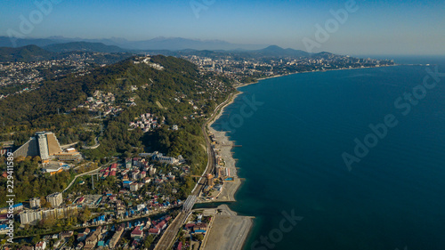 The Black Sea coast, the area of Sochi, the federal highway, on which cars drive, winding road among the trees, passing through the mountains along the coast.